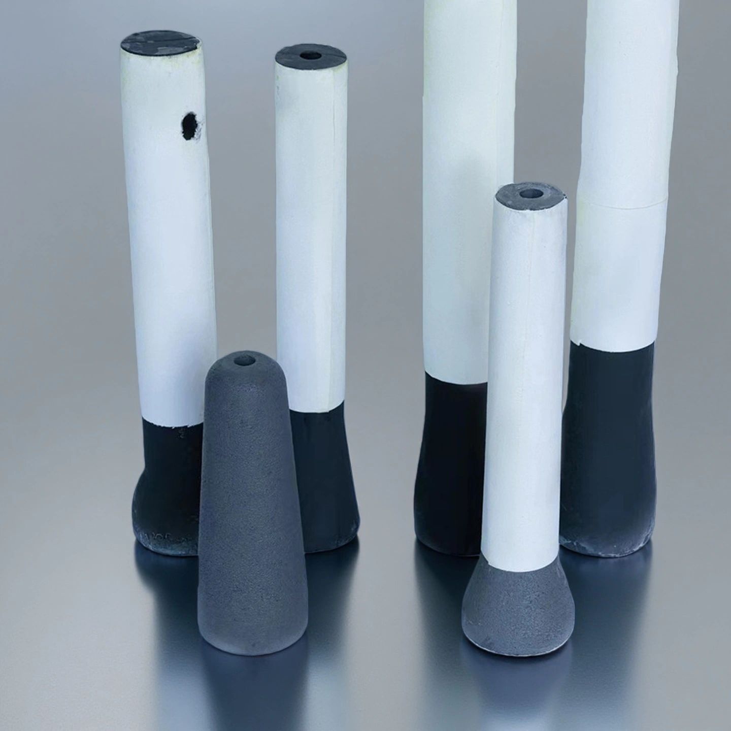 Multiple fused quartz submerged entry nozzles standing vertically on gray background