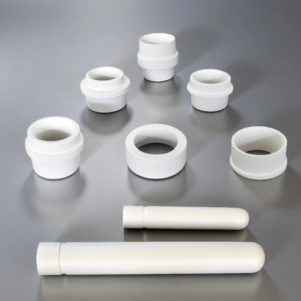 Aluminum titanate ceramic components including riser tubes and sprue bushes for molten aluminum systems