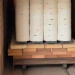 Stacked ceramic components are loaded inside an industrial kiln for high-temperature firing during ceramic production.
