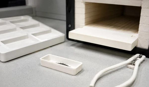 Alumina ceramic boat holding a powder sample for combustion and elemental analysis
